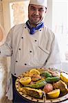 Chef avec plat de poisson et de légumes à Djerba, Tunisie