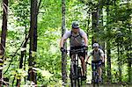 Zwei Männer-Mountainbiking im Wald