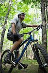 Mann im Wald mit Mountainbike