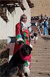 Une femme de la province du Yunnan en costume traditionnel avec un chien au Temple Songzanlin, Shangri-la, Chine