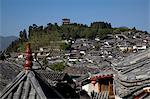 Les toits résidentiels anciens et Wan Gu Lou dans le lointain, la vieille ville de Lijiang, Province du Yunnan, Chine