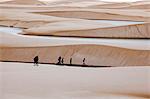 Tourists at Sandy dunes near Lagoa Bonita (Beautiful Lagoon) at Parque Nacional dos Lencois Maranhenses, Brazil