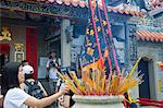 Adorateur offrant l'encens au Temple de Pak Tai pendant le festival Bun, Cheung Chau, Hong Kong