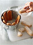 Placing the finger biscuits in the Charlotte mould