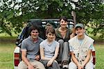 Young travelers sitting in back of pick-up truck, portrait