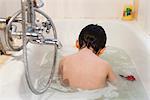 Boy taking a bath, rear view