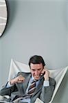 Mature businessman using cell phone, making fist and smiling