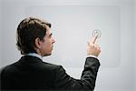 Businessman touching power button on advanced touch screen interface