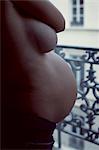 Semi-naked pregnant woman, mid section, side view