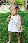 Baby girl holding daisy