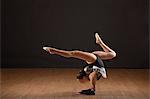 Gymnast bending backwards, balancing ball with head