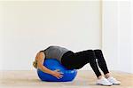 Woman lying on fitness ball