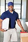 Portrait of a happy African American man carrying delivery boxes