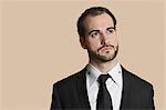 Young businessman looking away over colored background