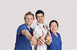 Porträt einer glücklich medizinischen team Gestikulieren Daumen bis über den grauen Hintergrund