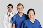 Portrait de standing équipe médicale variée sur fond gris