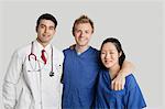 Portrait of friendly medical team standing over gray background