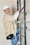 Portrait of a happy worker climbing scaffold