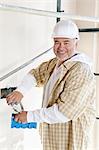 Portrait d'un homme mature joyeux tenue d'engins de chantier