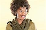 Happy African American woman with a stole round her neck looking away over colored background