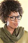 Portrait of an African American woman wearing glasses with a stole round her neck over colored background