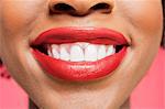 Close-up detail of an African American woman smiling over colored background