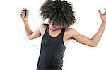 Young man with curly hair enjoying while listening to mp3 player over white background