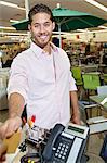 Portrait of a happy young man paying through credit card