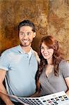 Beautiful young couple with color samples smiling while looking away