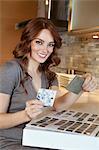 Portrait d'une jeune femme heureuse avec des échantillons de tile dans le modèle de la maison