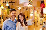 Portrait of young couple with price tag in lights store