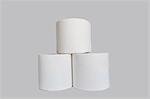 Stacks of rolls of toilet paper on white background