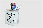 Gros plan du pense-bête avec message d'yoga sur un porte-stylo sur fond blanc