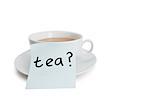 Close-up of sticky notepaper with teacup over white background