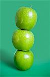 Stack of green apples over colored background