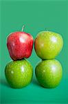 Stack of red and green apples over colored background