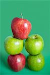 Pile of red and green apples over colored background