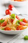 penne pasta with fresh cherry tomatoes and basil leaves