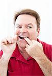 Man flossing his teeth in the mirror.  Good oral hygiene.