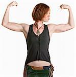 Serious young woman flexing her biceps over white