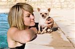 portrait of a cute purebred  chihuahua and young woman in the swimming pool