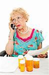 Senior woman on the phone discussing her medical bills with the health insurance company.  White background.