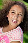 Portrait photograph of a beautiful young smiling happy mixed race interracial African American girl, shot outside in a park