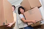 Two young women moving boxes