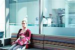 Woman in hospital waiting room with bouquet