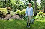 Femme avec un arrosoir et de betterave rouge dans le jardin