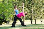 Yoga instructor and student in park