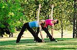 Two women practising yoga together in a park