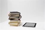 Stack of books with digital tablet