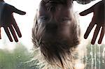 Boy looking through window, upside down